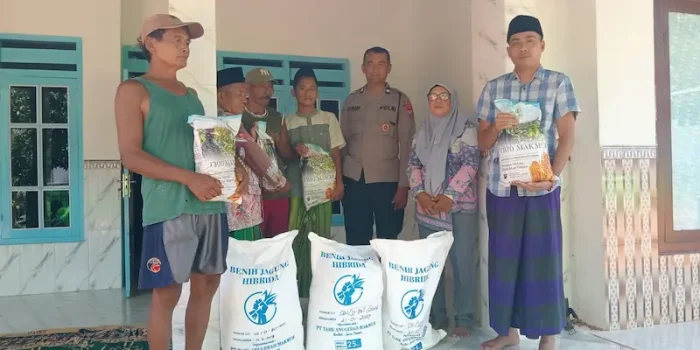 Anggota Polri bersama penyuluh pertanian menyerahkan karung bibit jagung hibrida kepada ketua kelompok tani di Sumenep.
