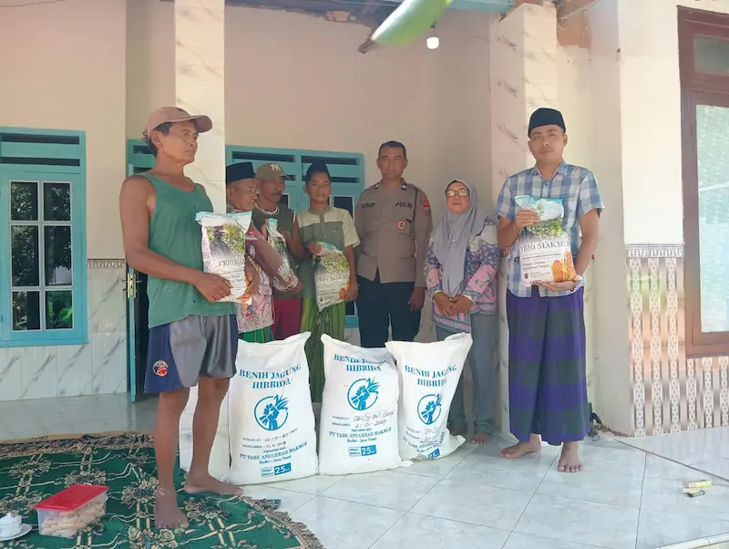 Anggota Polri bersama penyuluh pertanian menyerahkan karung bibit jagung hibrida kepada ketua kelompok tani di Sumenep.